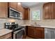 Close-up of kitchen area with stainless steel appliances and light tile backsplash at 814 Ember Dr, Durham, NC 27703