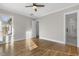 A bright bedroom has hardwood floors, a ceiling fan, and large windows offering ample natural light at 818 St Charles St, Durham, NC 27713