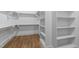 The walk in closet features built in shelves and wooden floors at 818 St Charles St, Durham, NC 27713