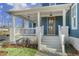 Inviting front porch with white railings, painted brick columns, and a stylish wood front door at 818 St Charles St, Durham, NC 27713