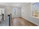 A well lit hallway features hardwood floors, staircase and large windows at 818 St Charles St, Durham, NC 27713
