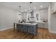 A spacious kitchen features an island with bar seating, modern pendant lighting, and stainless steel appliances at 818 St Charles St, Durham, NC 27713