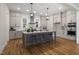 A spacious kitchen features an island with bar seating, modern pendant lighting, and stainless steel appliances at 818 St Charles St, Durham, NC 27713