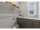 The well lit laundry room features a sink, cabinets and a window at 818 St Charles St, Durham, NC 27713