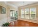 Bright dining room featuring hardwood floors, large windows, and sliding door access to the sunroom at 830 Finnbar Dr, Cary, NC 27519