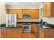 Well-equipped kitchen with wood cabinets, stainless steel appliances, granite counters, and hardwood flooring at 830 Finnbar Dr, Cary, NC 27519