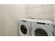 Convenient laundry area with a Whirlpool washer and dryer, and a wire shelf for storage at 830 Finnbar Dr, Cary, NC 27519