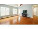 Bright living room with hardwood floors, ceiling fan, and large windows that allow plenty of natural light at 830 Finnbar Dr, Cary, NC 27519