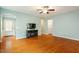 Spacious living room with hardwood floors, large windows, and a cozy fireplace, perfect for relaxing at 830 Finnbar Dr, Cary, NC 27519