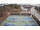 Aerial view of two pickleball courts near a pond with a fountain and homes in the background at 830 Finnbar Dr, Cary, NC 27519