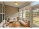 Cozy sunroom featuring wood paneling, ceiling fan and natural light through large windows at 830 Finnbar Dr, Cary, NC 27519