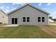 Backyard view with sliding glass doors, green siding, and grass at 841 Kenyon Spring Dr, Zebulon, NC 27597