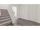 Bright entryway featuring hardwood floors, stairs with carpet, and a white front door at 841 Kenyon Spring Dr, Zebulon, NC 27597