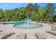 Community pool area with chaise lounges, a fountain, and mature trees at 841 Kenyon Spring Dr, Zebulon, NC 27597