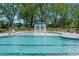 Community pool and fountain area with chaise lounges and lush green trees at 841 Kenyon Spring Dr, Zebulon, NC 27597
