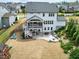 Aerial view of the backyard with a screened-in porch and stone patio with outdoor kitchen at 853 Rambling Oaks Ln, Holly Springs, NC 27540