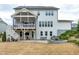 Expansive backyard with a beautiful screened-in porch, stone patio, and outdoor kitchen area at 853 Rambling Oaks Ln, Holly Springs, NC 27540
