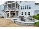 Paver patio with stone seat wall, outdoor kitchen with grill, and a covered porch at 853 Rambling Oaks Ln, Holly Springs, NC 27540