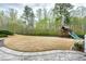 Landscaped backyard with a play set and paver patio at 853 Rambling Oaks Ln, Holly Springs, NC 27540