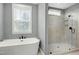 Bright bathroom featuring a soaking tub and glass shower, perfect for relaxation at 853 Rambling Oaks Ln, Holly Springs, NC 27540