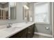 Bathroom featuring a dual vanity with dark cabinets, a large mirror, and a window for natural light at 853 Rambling Oaks Ln, Holly Springs, NC 27540