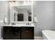 Sleek bathroom featuring a double vanity with dark wood cabinets, a large mirror, and modern fixtures at 853 Rambling Oaks Ln, Holly Springs, NC 27540