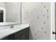 Modern bathroom boasts patterned wallpaper, a large mirror, dark cabinets, and a stylish sink and faucet at 853 Rambling Oaks Ln, Holly Springs, NC 27540
