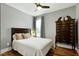 Bedroom featuring a dark wood bed, hardwood flooring, soft lighting, and a stylish chest of drawers at 853 Rambling Oaks Ln, Holly Springs, NC 27540