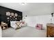 This stylish bedroom showcases a black accent wall, crib, rocker chair, and decorative flower accents at 853 Rambling Oaks Ln, Holly Springs, NC 27540