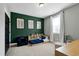 Stylish bedroom features a green accent wall, neutral furniture, decor, and large windows for natural light at 853 Rambling Oaks Ln, Holly Springs, NC 27540