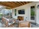 Cozy covered patio with comfortable seating and an outdoor television at 853 Rambling Oaks Ln, Holly Springs, NC 27540