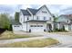 Charming white two-story home with a large driveway and a detached garage at 853 Rambling Oaks Ln, Holly Springs, NC 27540