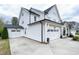 Side view of a two-story home showcasing a detached garage and ample driveway space at 853 Rambling Oaks Ln, Holly Springs, NC 27540