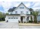 Inviting two-story home featuring a cozy front porch with comfortable seating at 853 Rambling Oaks Ln, Holly Springs, NC 27540