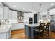 Bright, modern kitchen with white cabinets, stainless appliances, and a gray island with white countertop and seating at 853 Rambling Oaks Ln, Holly Springs, NC 27540