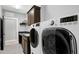Spacious laundry room features modern appliances, dark wood cabinets, and a sink for added convenience at 853 Rambling Oaks Ln, Holly Springs, NC 27540