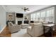 Inviting living room with a fireplace, neutral sofa, patterned chair, ottoman, ceiling fan, and a large window at 853 Rambling Oaks Ln, Holly Springs, NC 27540