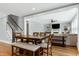 An open-concept living area is joined by a dining table, staircase, and a living room with a fireplace at 853 Rambling Oaks Ln, Holly Springs, NC 27540
