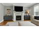 Cozy living room featuring a fireplace with white mantle, a large TV, a gray accent wall, and furniture at 853 Rambling Oaks Ln, Holly Springs, NC 27540