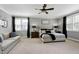 Bright and airy main bedroom featuring a sitting area, comfortable bed and large windows at 853 Rambling Oaks Ln, Holly Springs, NC 27540