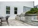 Custom outdoor kitchen on the patio featuring a built-in grill and dining area at 853 Rambling Oaks Ln, Holly Springs, NC 27540
