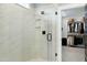 Modern glass shower next to a walk-in closet in the primary bathroom at 853 Rambling Oaks Ln, Holly Springs, NC 27540