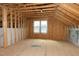 Bright unfinished attic space with framed walls, wood floors and a window providing ample light at 853 Rambling Oaks Ln, Holly Springs, NC 27540