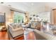 Sunlit living room features hardwood floors, neutral furniture, and an open layout to the kitchen at 9 Hayden Pond Ln, Chapel Hill, NC 27517