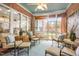 Bright sunroom features brick walls, a patterned rug, and comfortable seating with views of the landscaped backyard at 9 Hayden Pond Ln, Chapel Hill, NC 27517