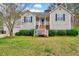 Charming home featuring a well-manicured lawn, complemented by a welcoming front porch and two-car garage at 91 Buckingham Ct, Smithfield, NC 27577