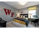 Stylish bedroom featuring a cozy bed, modern desk, and vibrant red lettering on the accent wall at Lot 1 Northpointe Farms Trl, Efland, NC 27243