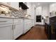 Modern kitchen with white cabinets, stainless steel appliances, and a stylish chevron backsplash design at Lot 1 Northpointe Farms Trl, Efland, NC 27243