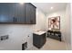 Clean laundry room with gray cabinets, white shiplap walls, and modern fixtures, creating a functional space at Lot 1 Northpointe Farms Trl, Efland, NC 27243