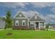 Charming single-story home with a brick foundation, green siding, a covered porch, and a well-manicured lawn at Lot 2 Northpointe Farms Trl, Efland, NC 27243